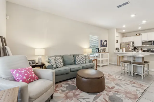 a living room with furniture and kitchen view