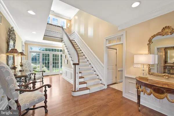 a kitchen with stainless steel appliances granite countertop a stove top oven a sink dishwasher a dining table and chairs with wooden floor