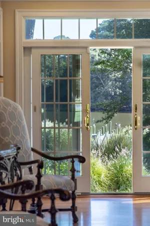 a kitchen with kitchen island granite countertop a dining table chairs wooden cabinets and white stainless steel appliances