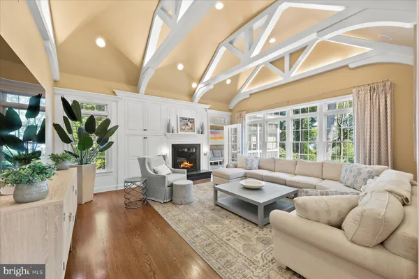 a dining room with wooden floor a chandelier a wooden table and chairs