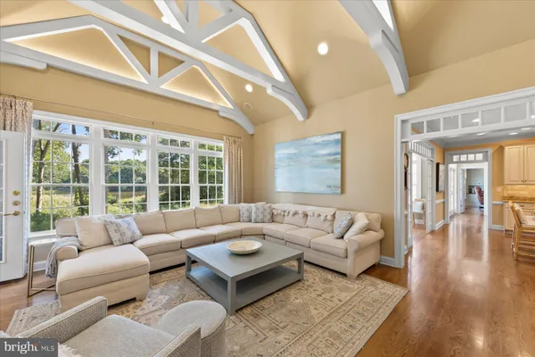 a dining hall with stainless steel appliances granite countertop a table chairs and a large window