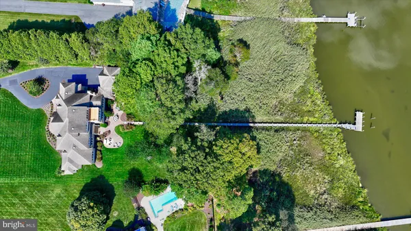 a view of a big house with a big yard and a large tree