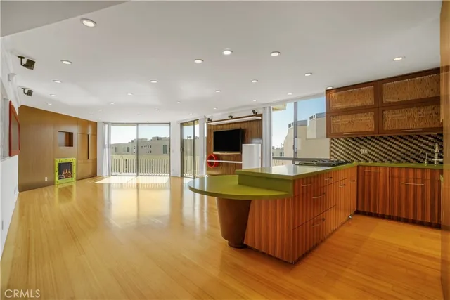 a kitchen with stainless steel appliances granite countertop a sink and wooden floor