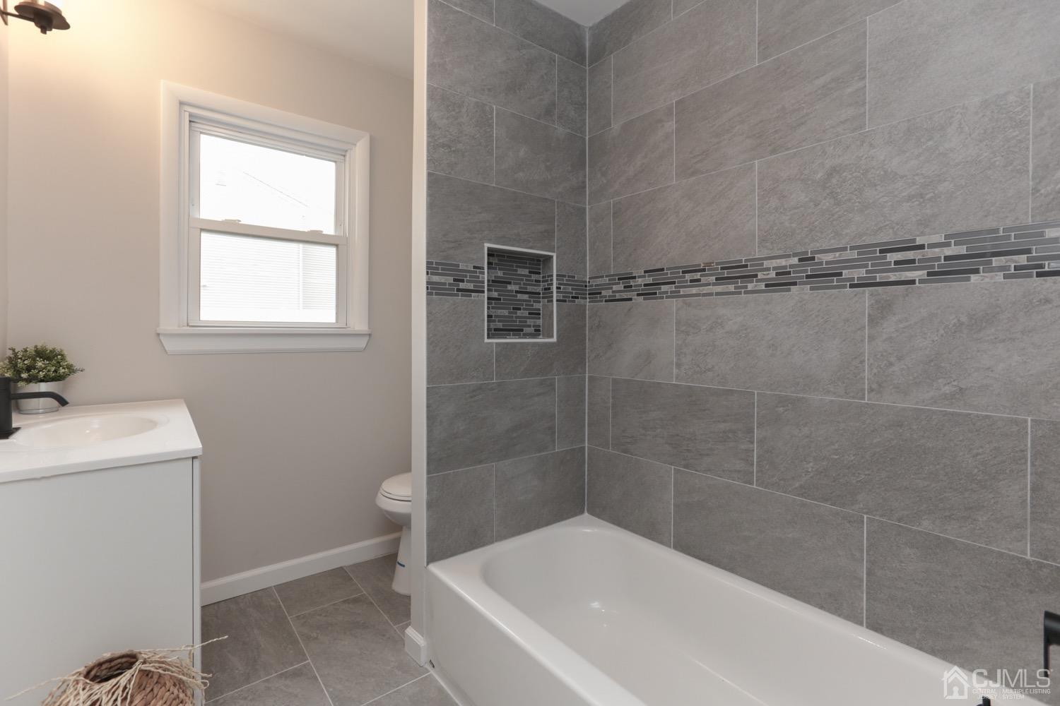 50 Hillcrest Road Colonia, NJ 07067 - Photo 8 of 24 a white bath tub sitting next to a white toilet and a window
