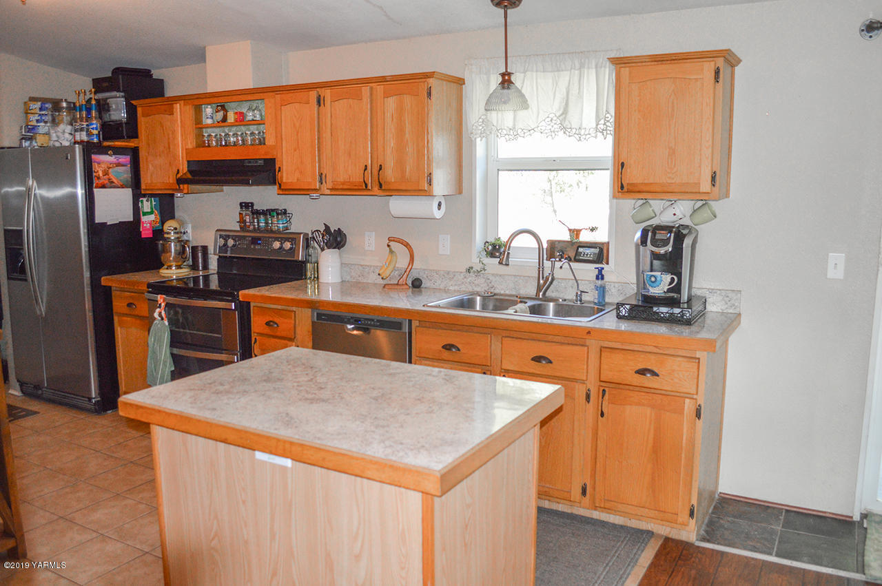 513 Burnham Road Yakima, WA 98908 - Photo 2 of 18 a kitchen with stainless steel appliances a sink cabinets and a refrigerator