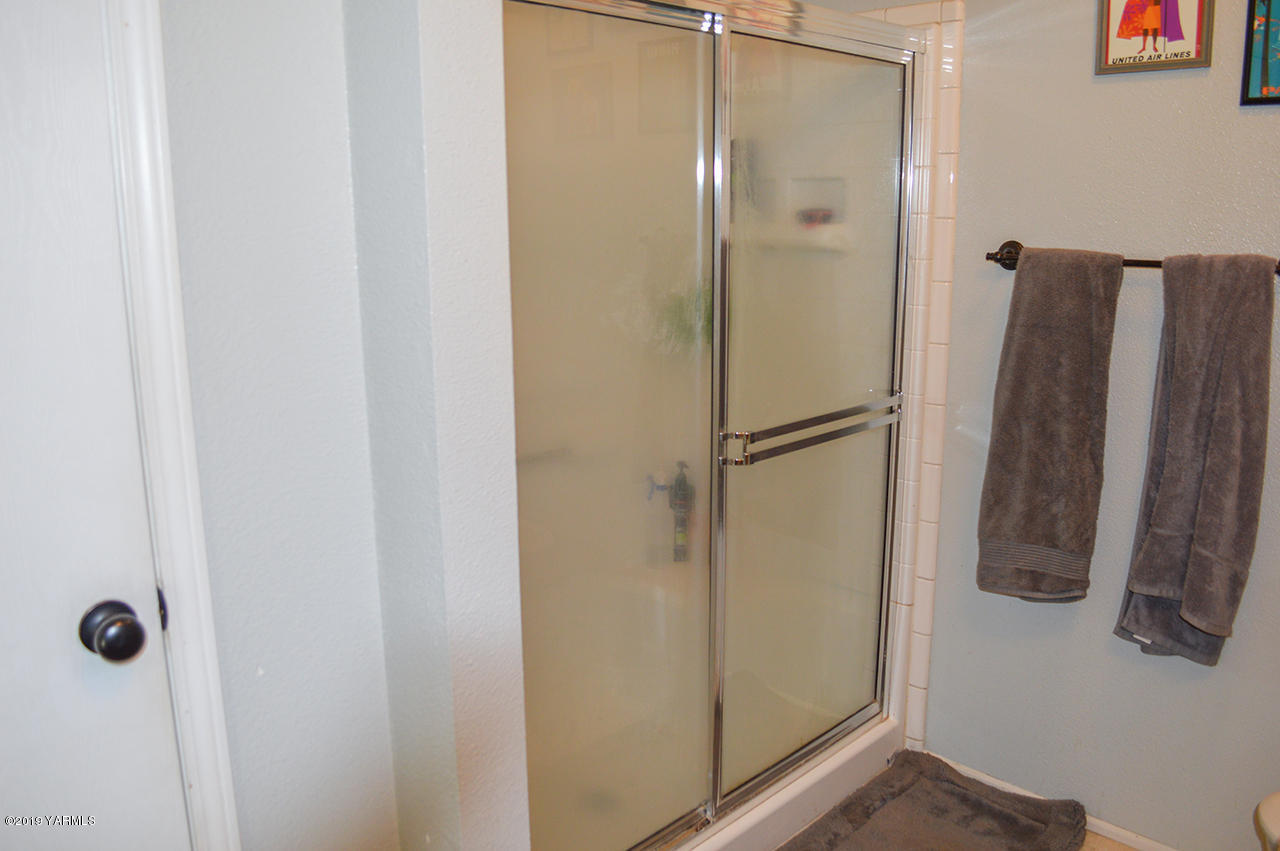 513 Burnham Road Yakima, WA 98908 - Photo 11 of 18 a bathroom with a shower and a glass door