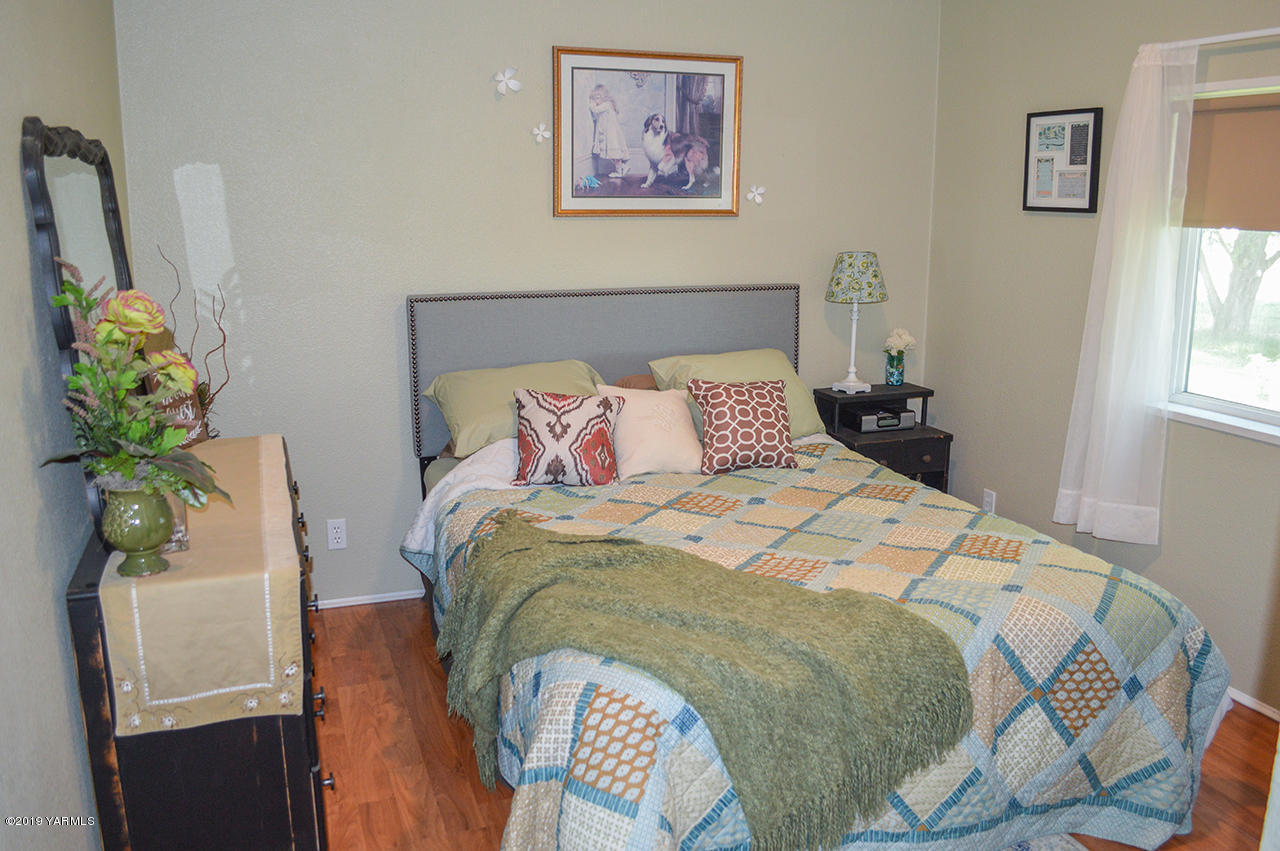 513 Burnham Road Yakima, WA 98908 - Photo 13 of 18 a bedroom with a bed and a painting on the wall