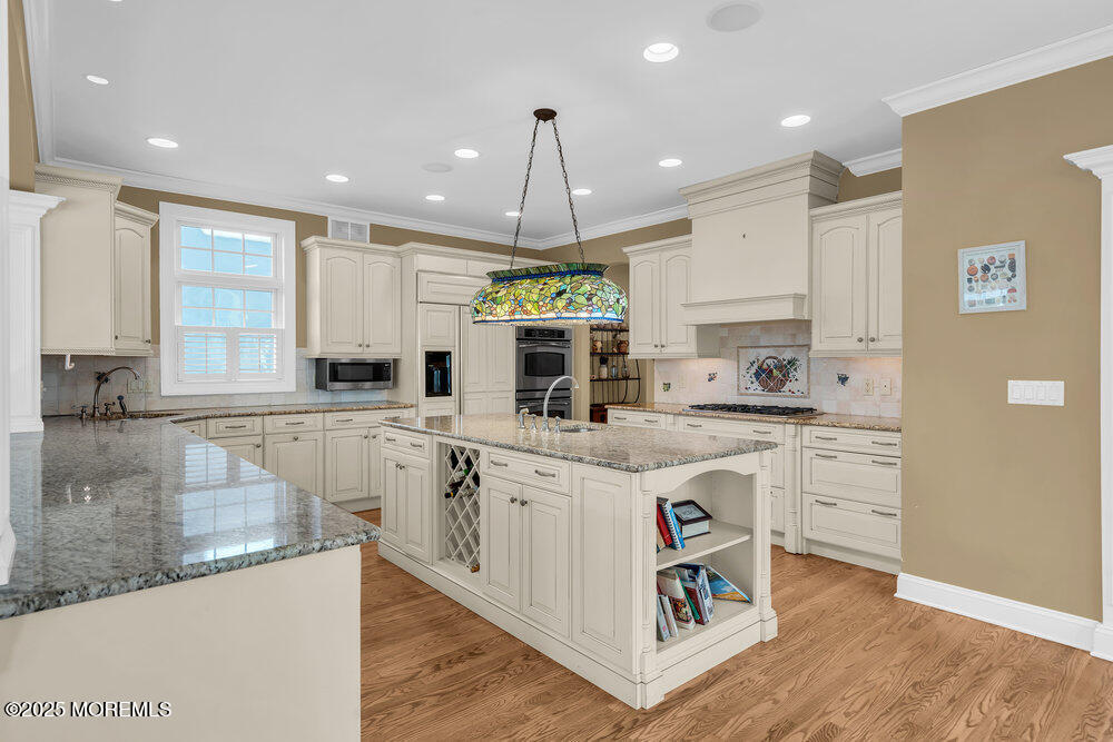 412 Chicago Boulevard Sea Girt, NJ 08750 - Photo 14 of 47 a large kitchen with kitchen island granite countertop a stove a sink a refrigerator and white cabinets with wooden floor