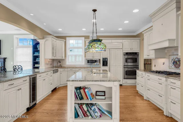 a large kitchen with stainless steel appliances granite countertop a stove and cabinets
