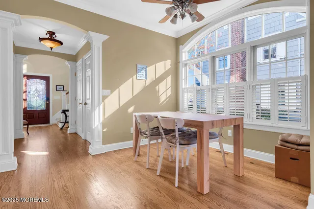 a dining room with wooden floor a chandelier a wooden table and chairs