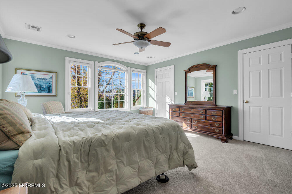 412 Chicago Boulevard Sea Girt, NJ 08750 - Photo 28 of 47 a spacious bedroom with a large bed and a chandelier