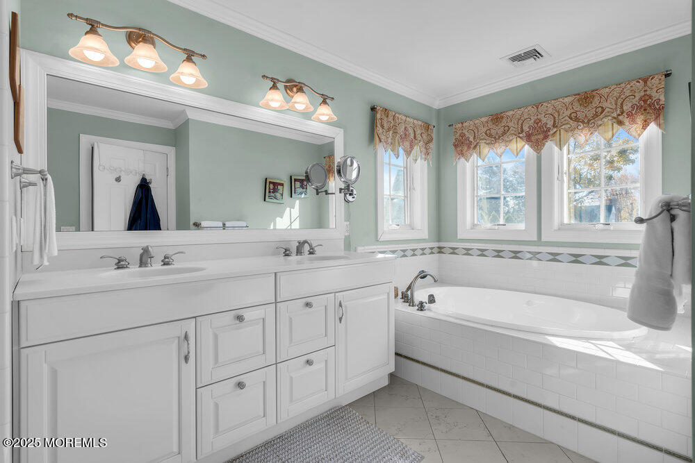 412 Chicago Boulevard Sea Girt, NJ 08750 - Photo 31 of 47 a spacious bathroom with a double vanity sink a large mirror a bathtub and next to a window