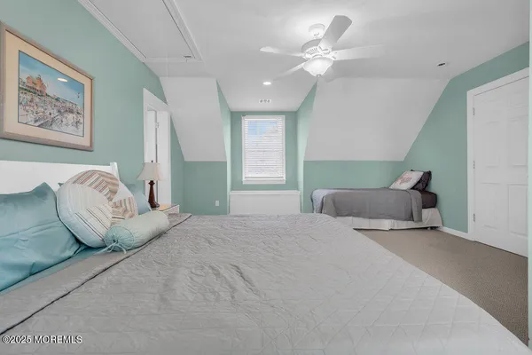 a bedroom with a large bed and a chandelier