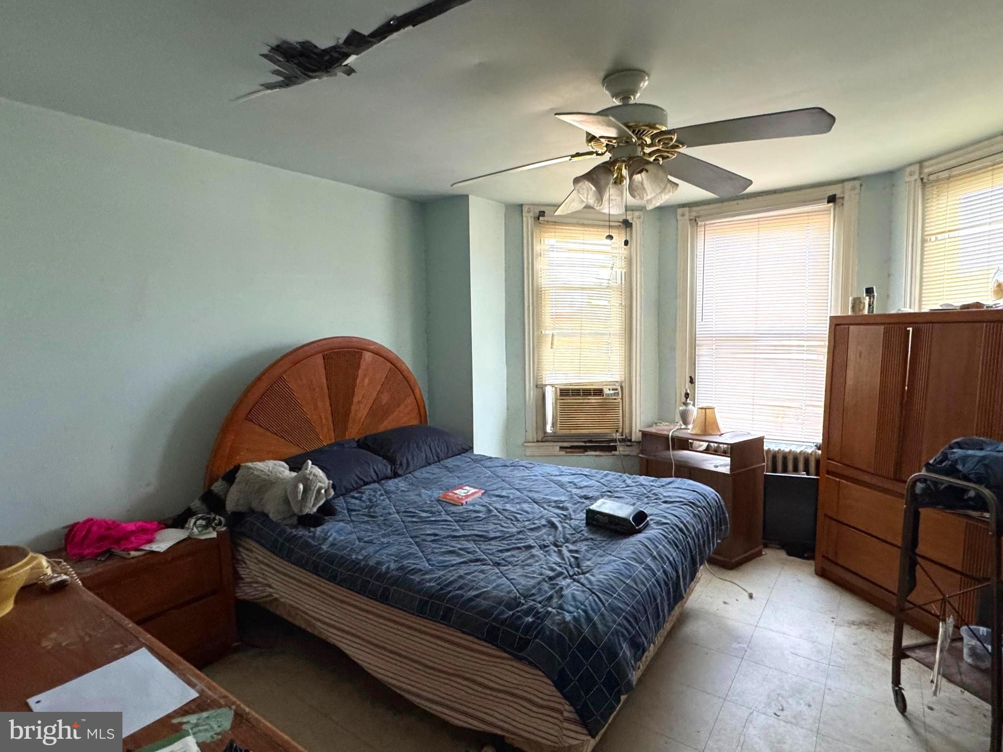 5702 Belmar Street Philadelphia, PA 19143 - Photo 11 of 14 a bedroom with a bed and a chandelier