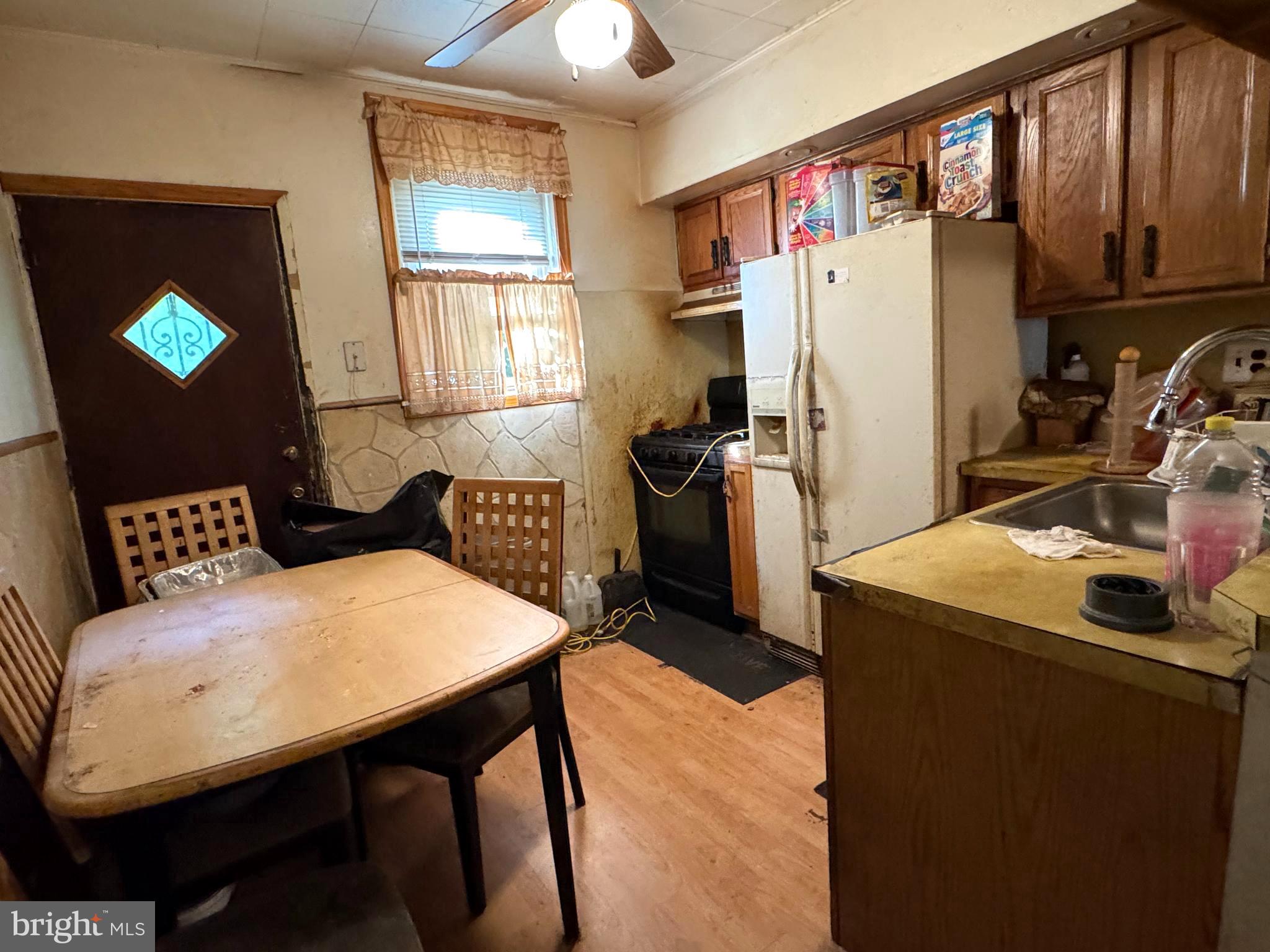 5702 Belmar Street Philadelphia, PA 19143 - Photo 6 of 14 a kitchen that has a refrigerator and a table in it