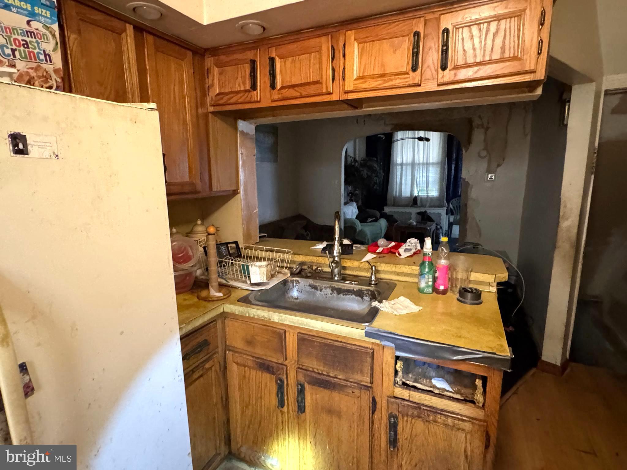 5702 Belmar Street Philadelphia, PA 19143 - Photo 7 of 14 a kitchen with a sink a refrigerator and cabinets