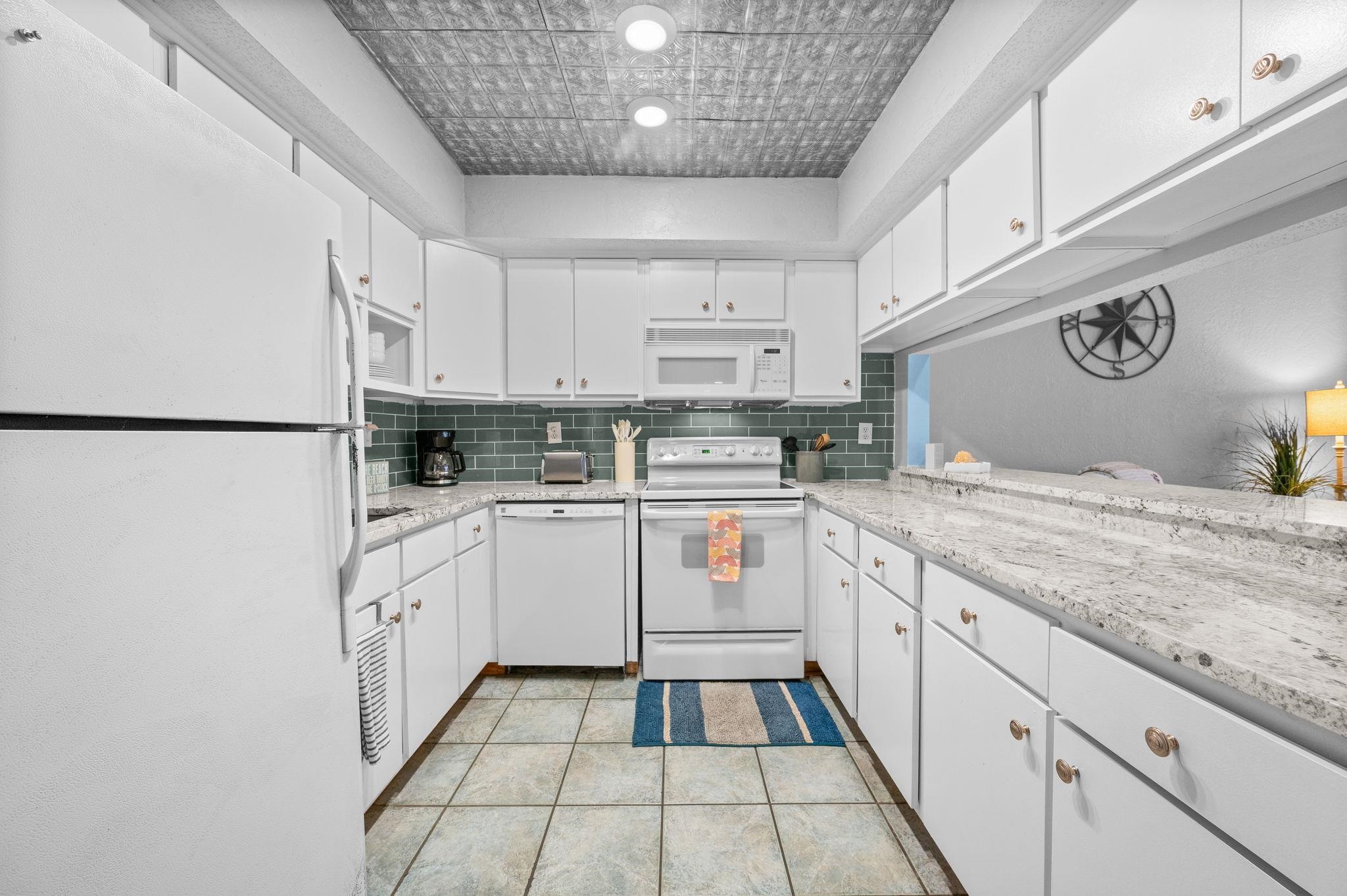 7175 A1A South, Unit F237 St. Augustine, FL 32080 - Photo 12 of 63 a kitchen with granite countertop white cabinets and white appliances