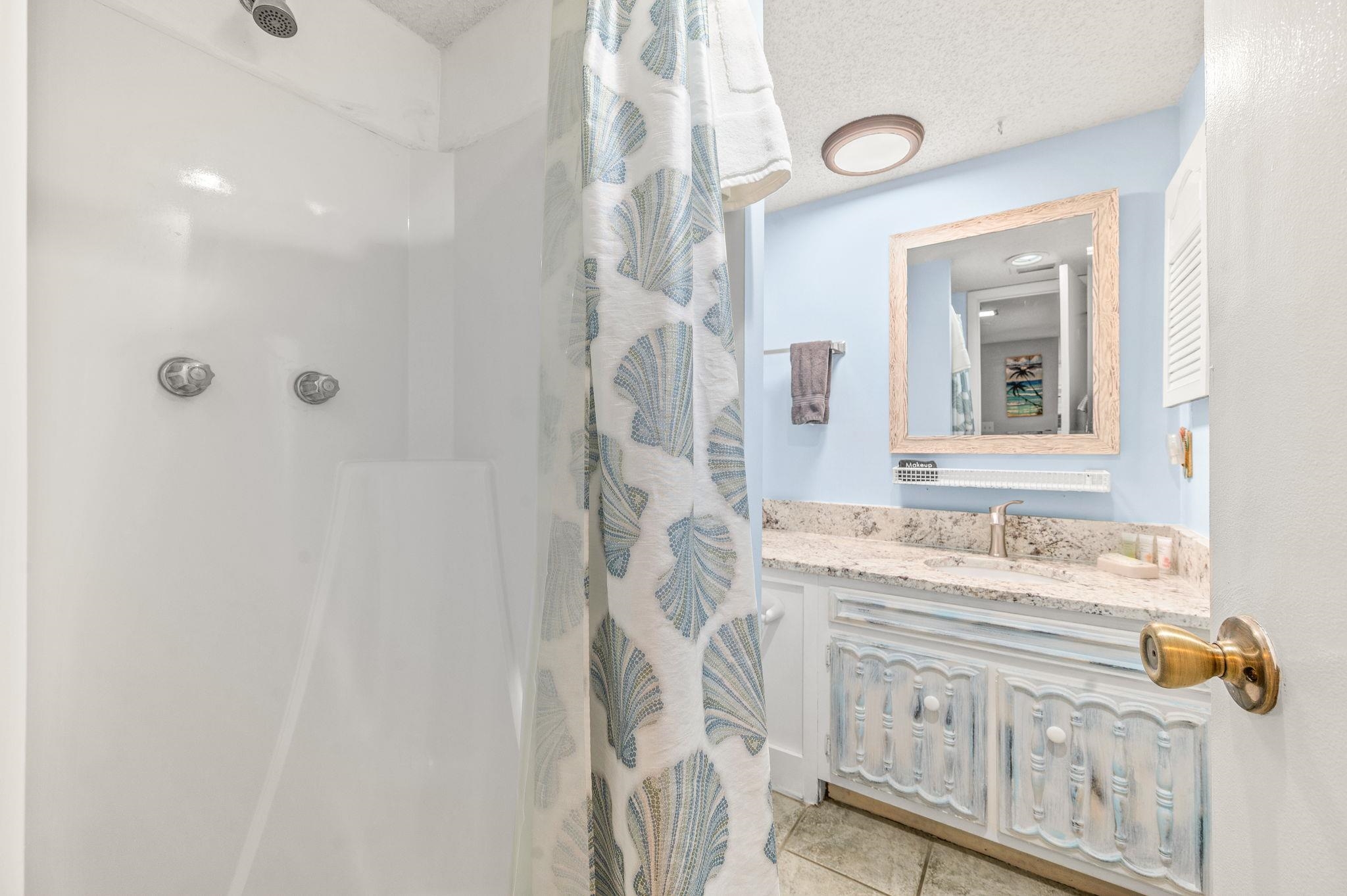 7175 A1A South, Unit F237 St. Augustine, FL 32080 - Photo 30 of 63 a bathroom with a sink a mirror and a shower