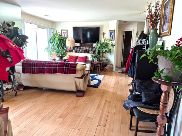 a bedroom with a bed a large window and a flat tv screen