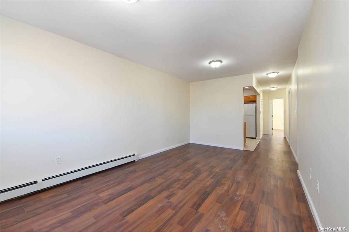 a view of a room with wooden floor and white walls