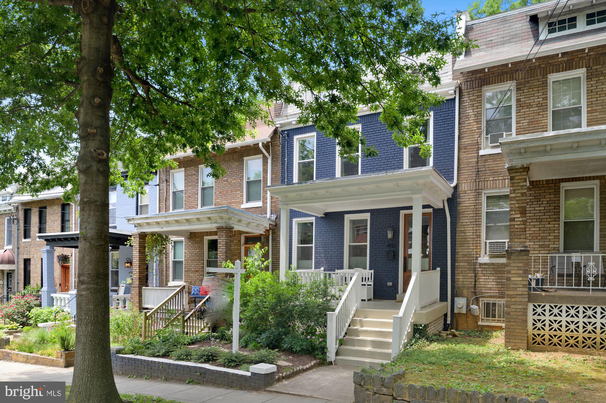 front view of a brick house with a small yard