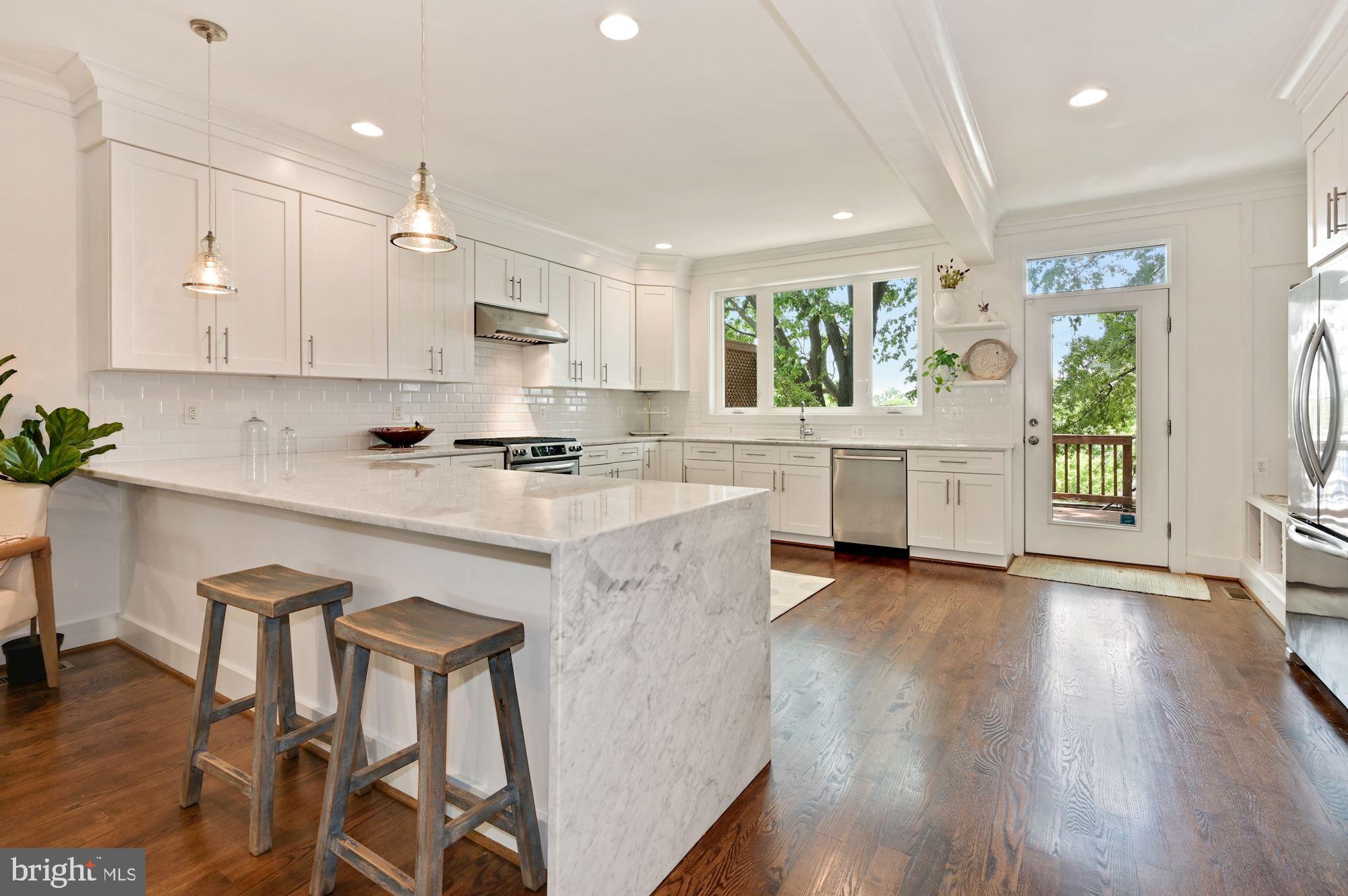 4110 3rd Street Northwest Washington, DC 20011 - Photo 11 of 35 a kitchen with stainless steel appliances granite countertop a stove a sink a refrigerator and white cabinets with wooden floor
