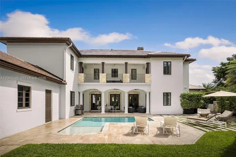 a view of white house with yard and couches