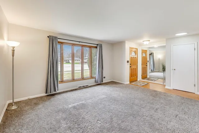 an empty room with a bathroom and a window