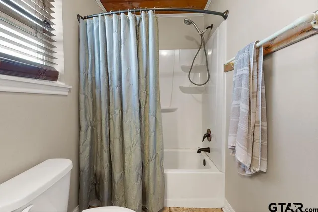 a bathroom with a shower a toilet and a shower