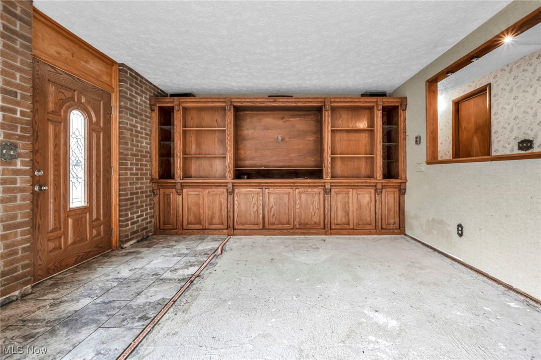 2680 Orchard Ext Road Wickliffe, OH 44092 - Photo 21 of 30 Unfurnished living room with a textured ceiling and brick wall