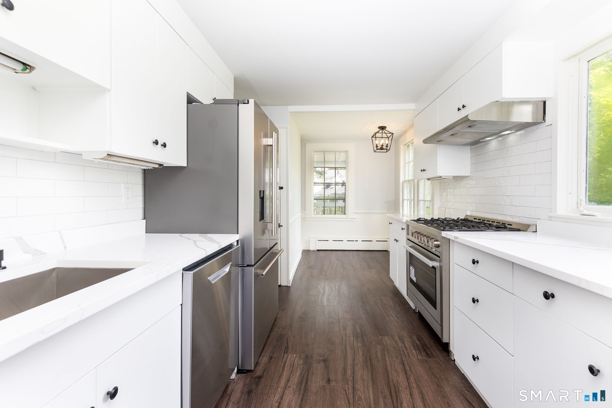 79 Deforest Street Watertown, CT 06795 - Photo 9 of 28 a large kitchen with a wooden floor and stainless steel appliances