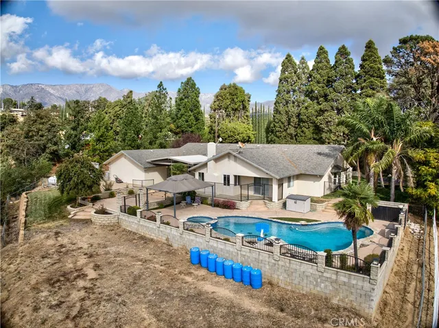 an aerial view of a house with table and chairs under an umbrella