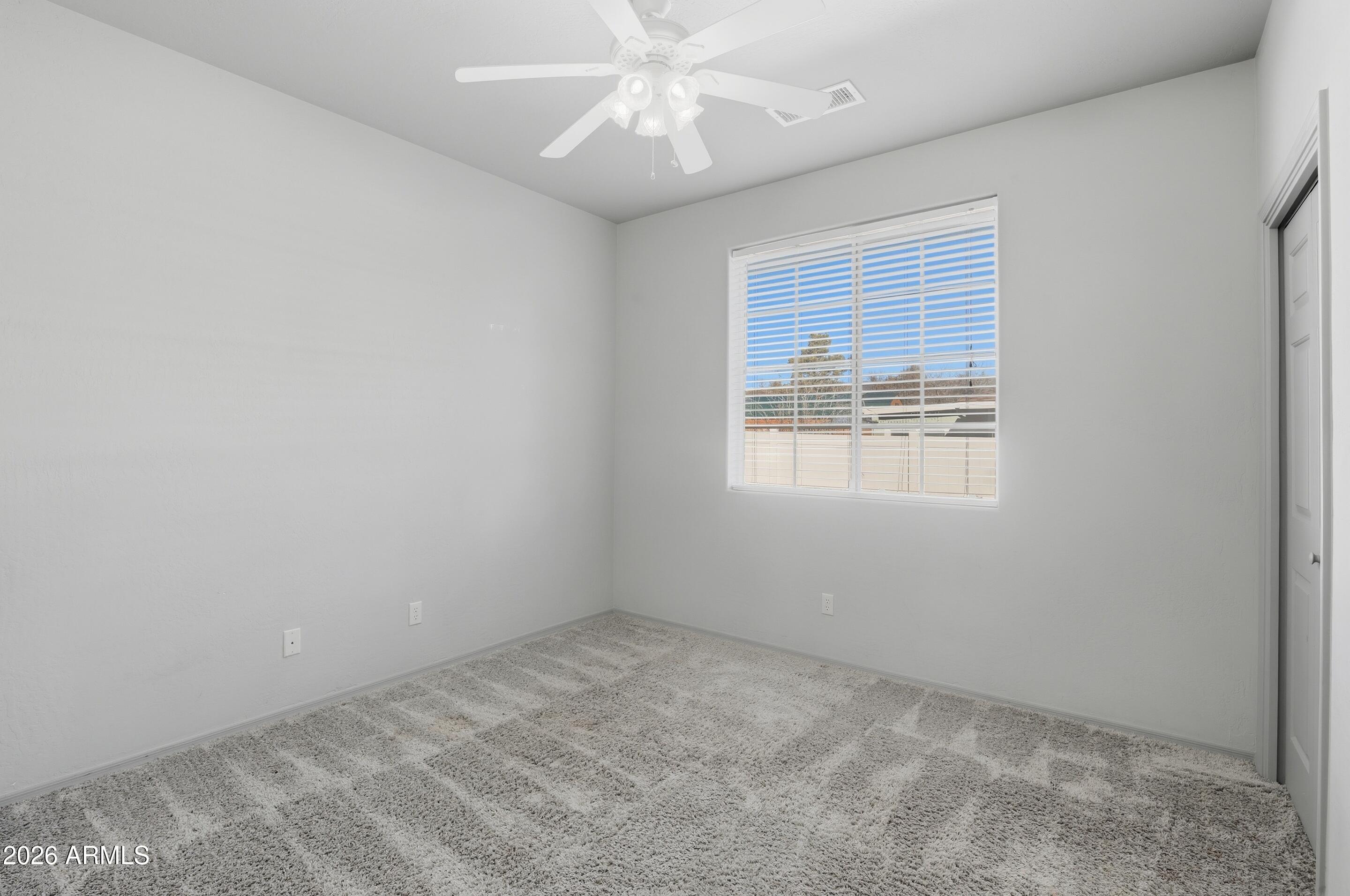 228 Windmill Road Payson, AZ 85541 - Photo 28 of 42 an empty room with a chandelier fan and windows
