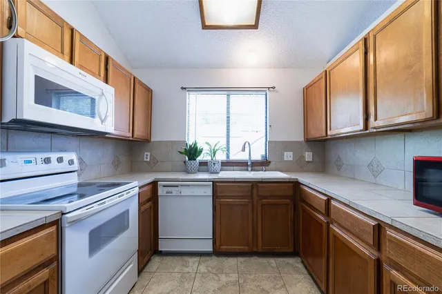 a kitchen with stainless steel appliances granite countertop a sink and stove top oven