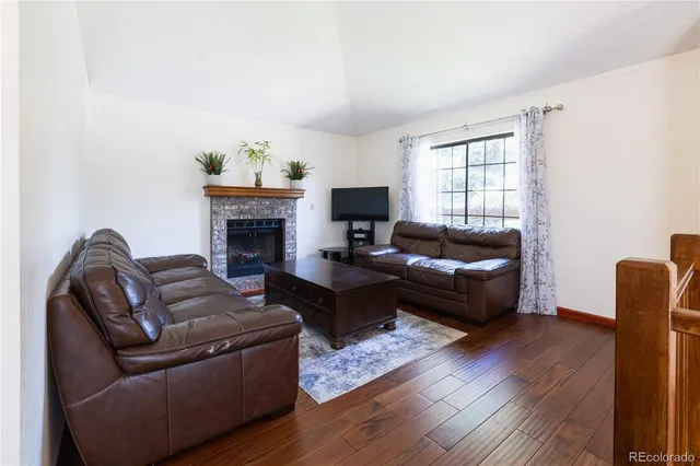a living room with furniture a fireplace and a flat screen tv