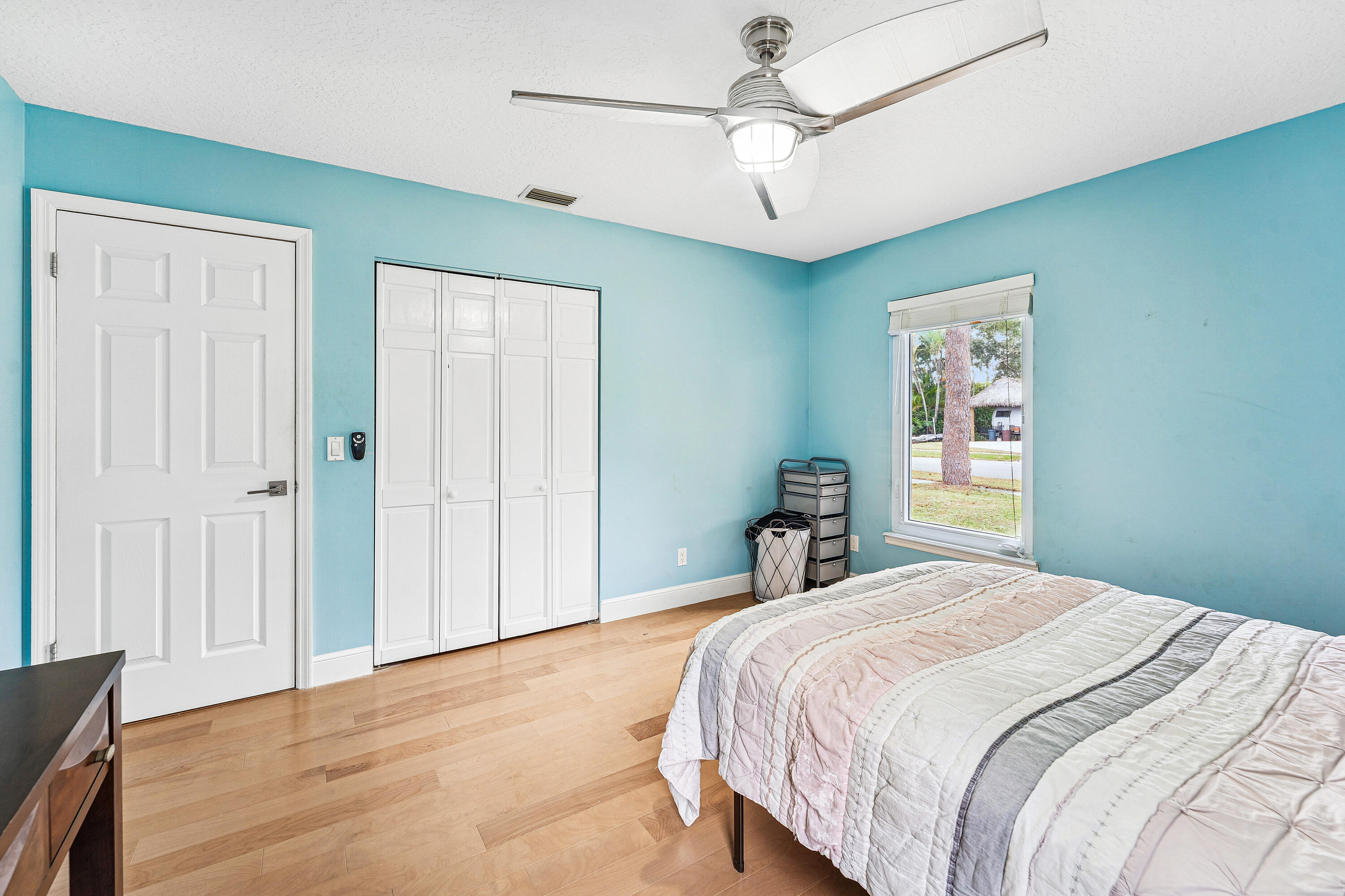 709 Warren Drive Jupiter, FL 33458 - Photo 23 of 56 a bedroom with a large bed and a chandelier