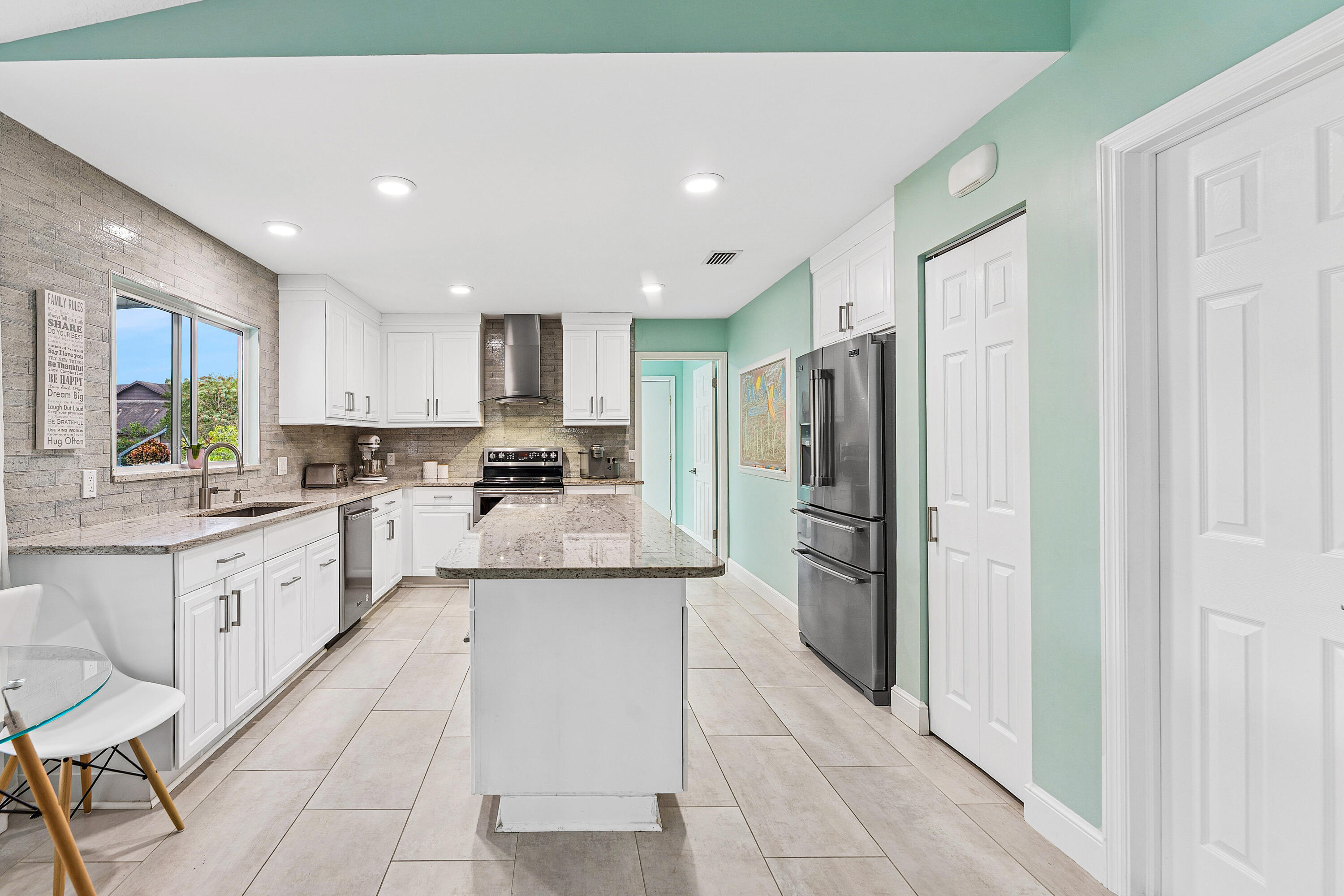709 Warren Drive Jupiter, FL 33458 - Photo 6 of 56 a kitchen with stainless steel appliances granite countertop a refrigerator and a stove top oven