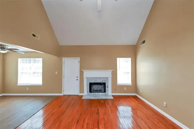 a view of empty room with wooden floor and fireplace