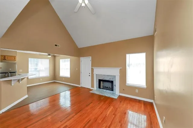a view of a big room with wooden floor and windows