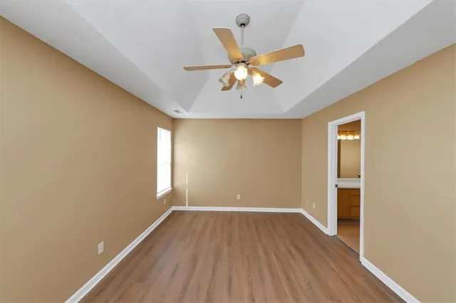 a view of room with hardwood floor and a ceiling fan