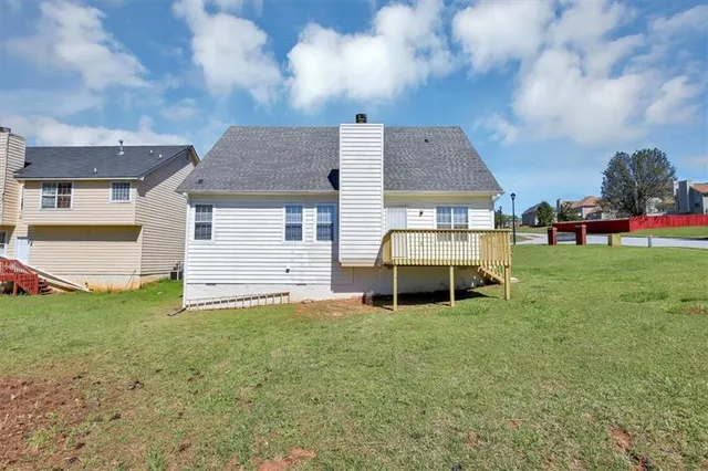 a front view of house with yard and trees in the background