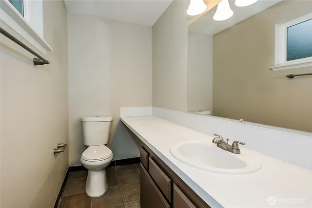 a bathroom with a sink a toilet and a mirror