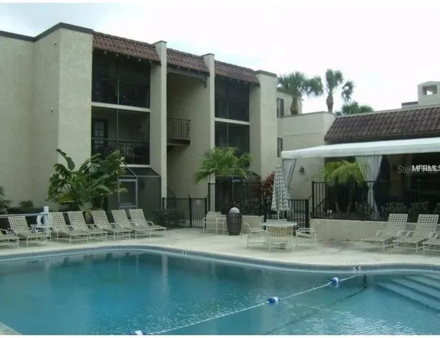 a view of swimming pool with outdoor seating and house in the background