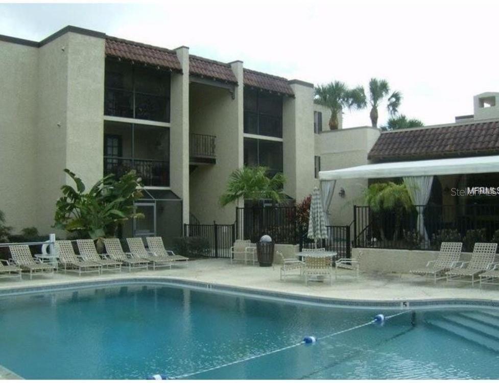 106 Alameda Court, Unit 139 Tampa, FL 33609 - Photo 2 of 13 a view of swimming pool with outdoor seating and house in the background