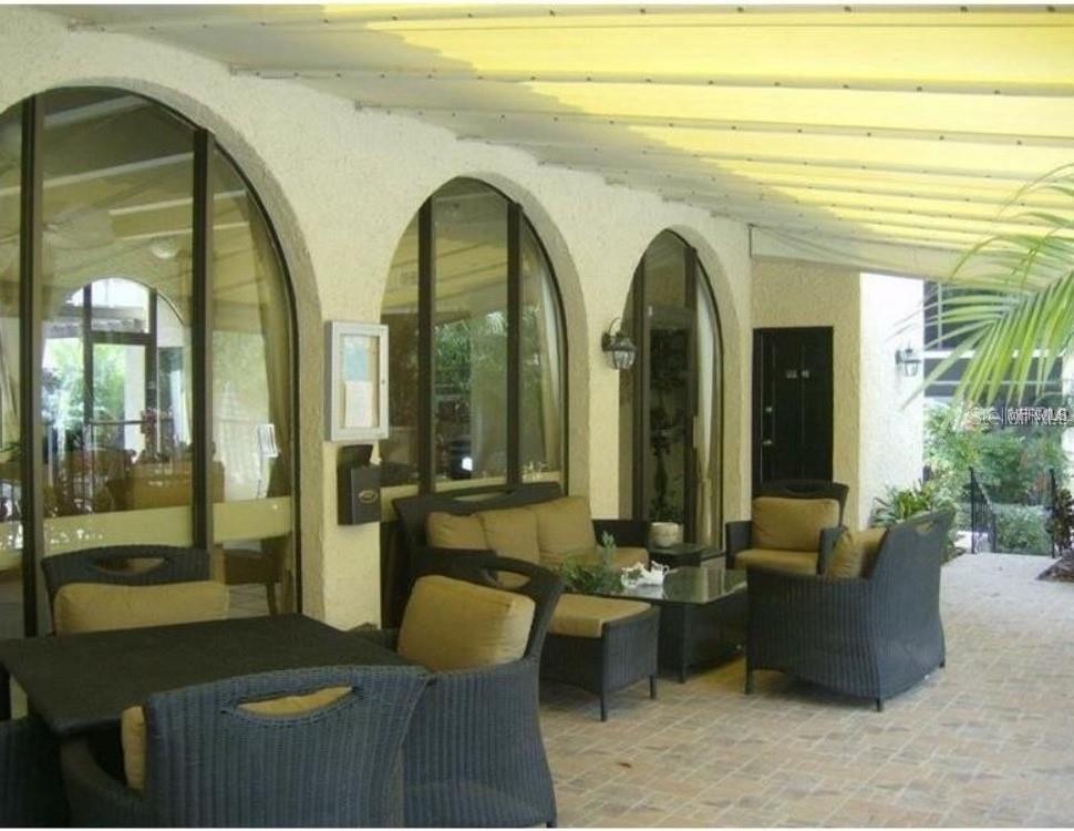 106 Alameda Court, Unit 139 Tampa, FL 33609 - Photo 4 of 13 a living room with couches and dining table with a potted plant