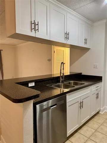 a kitchen with granite countertop white cabinets and a sink