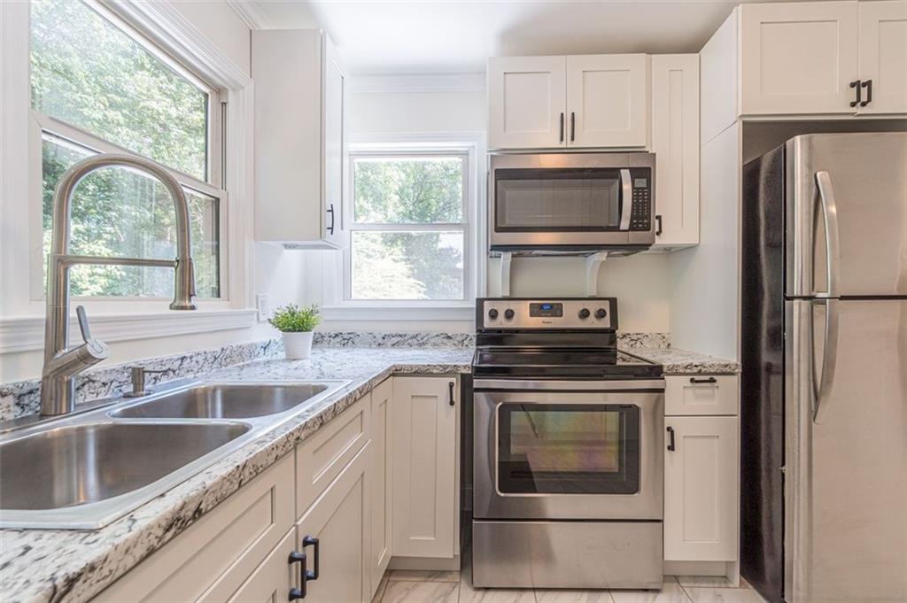 1226 Thomas Road Decatur, GA 30030 - Photo 30 of 38 a kitchen with a stove a sink and a refrigerator