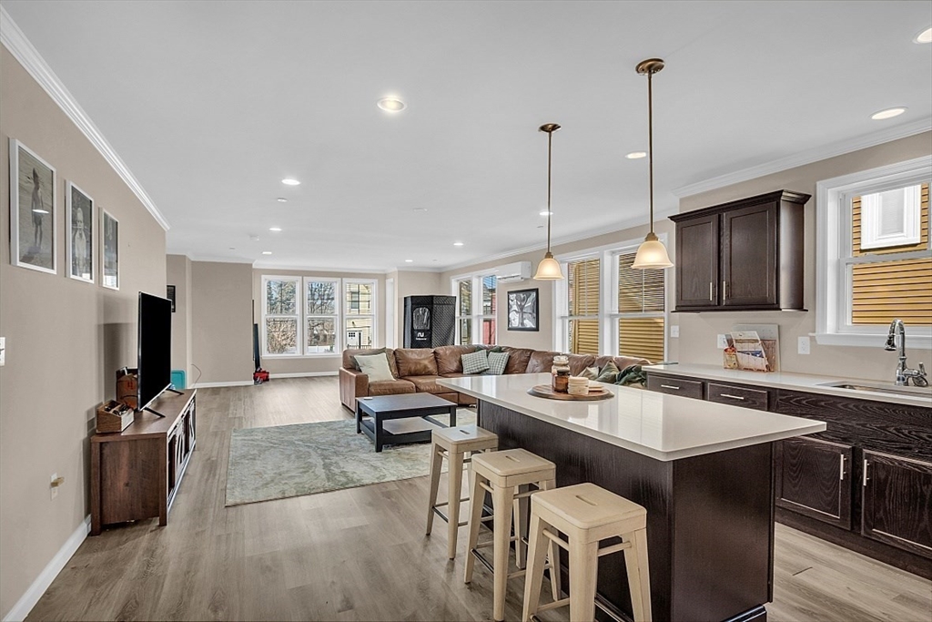 3 Elm Street, Unit 4 Boston, MA 02122 - Photo 1 of 24 a open kitchen with stainless steel appliances granite countertop a table chairs stove and refrigerator