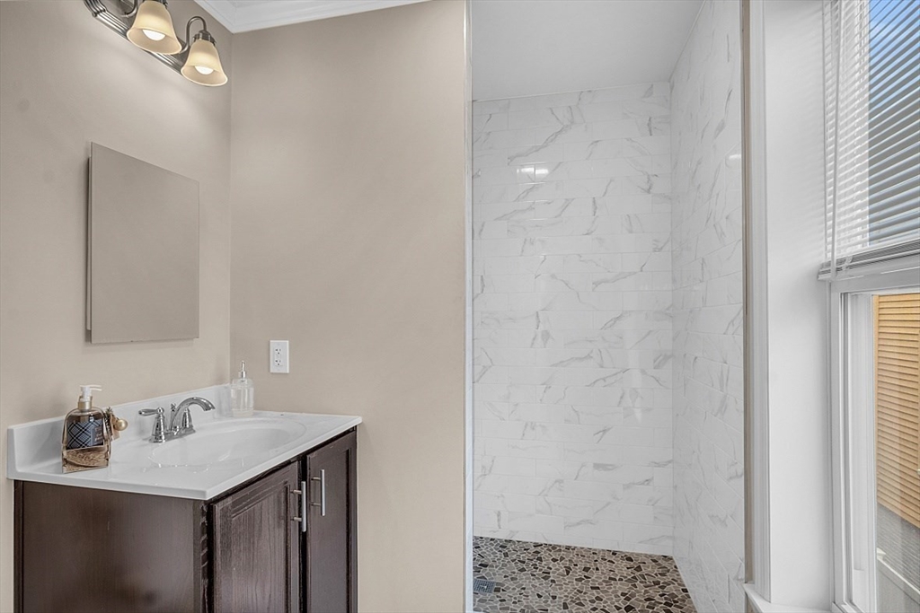 3 Elm Street, Unit 4 Boston, MA 02122 - Photo 12 of 24 a bathroom with a sink a mirror and a shower