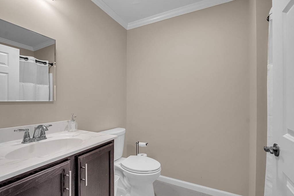 3 Elm Street, Unit 4 Boston, MA 02122 - Photo 15 of 24 a bathroom with a granite countertop sink a toilet and a mirror